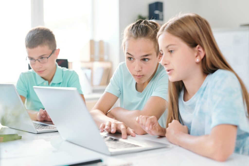 Middle school boy and girl looking at curious stuff on laptop display